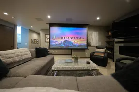 Stylish home theater featuring a large projection screen, modern seating, and elegant decor for an immersive viewing experience.